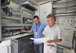 Joël Hourtoule (left) and Jean-Yves Journeaux in one of the twin "control towers" that collect and dispatch electrical power as well as data, thus providing a real-time picture of what's going on, electrically speaking, on the ITER worksite. 